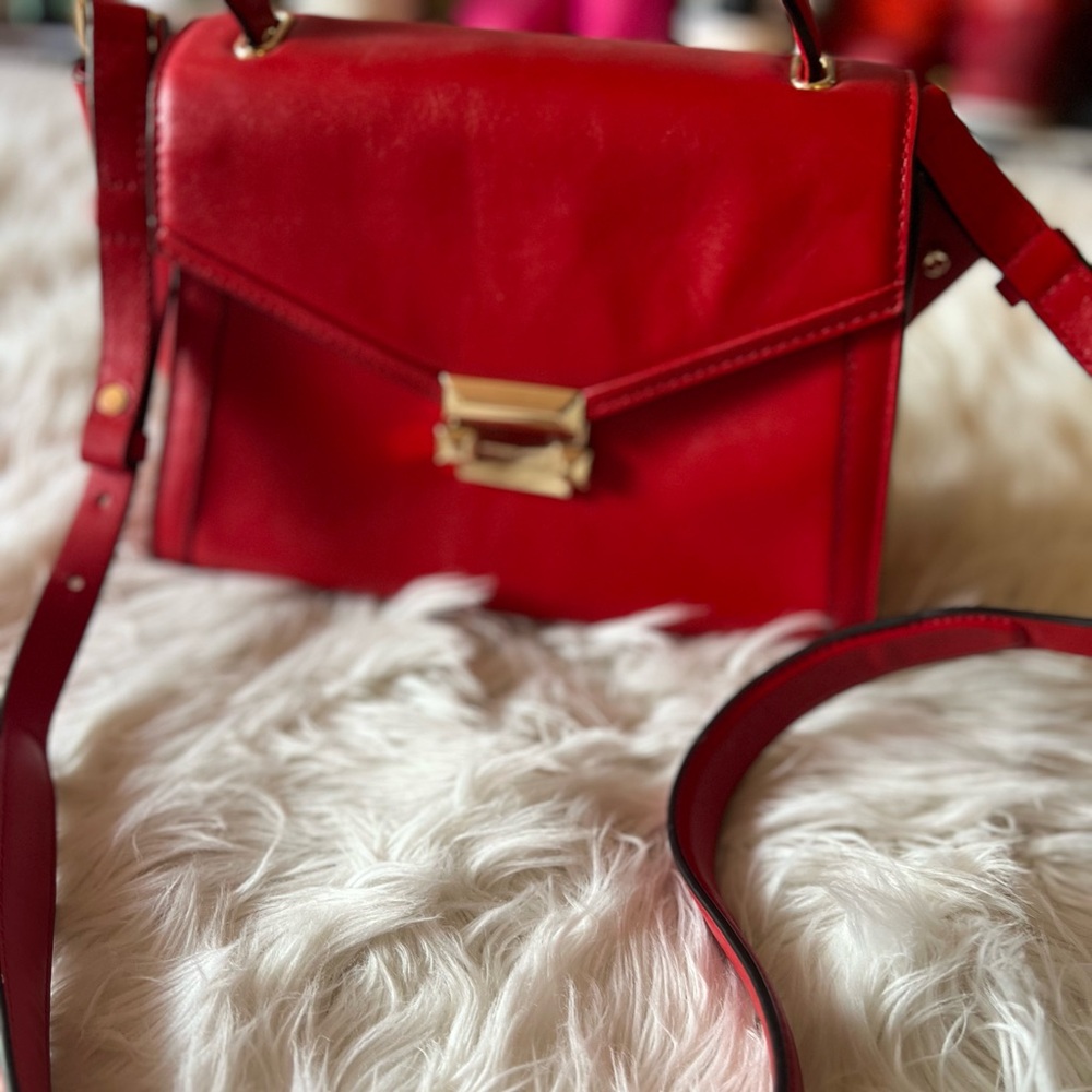 Red mid size crossbody Michel Kors purse.